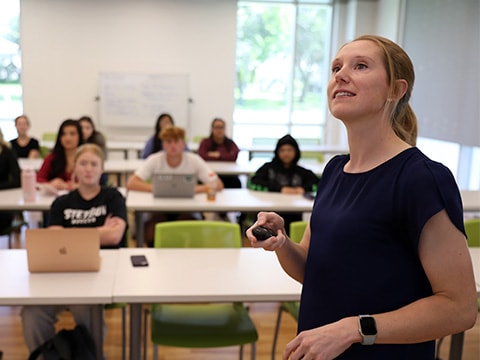 Professor teaching class with studentsin the background