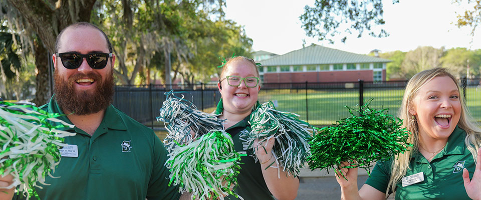 group photo of the admissions team cheering with pom poms