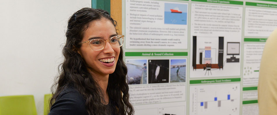 student smiling while showing science project to others