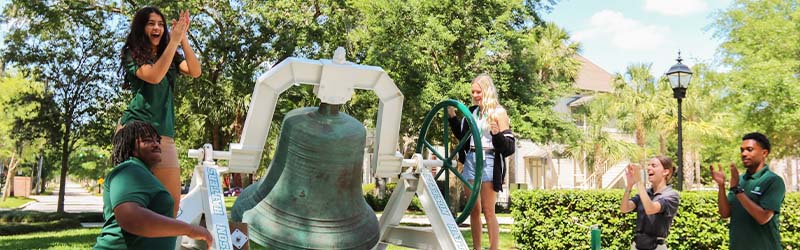 ambassadors ringing green bell with an incoming student