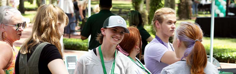 Students and families smiling outside during admissions event