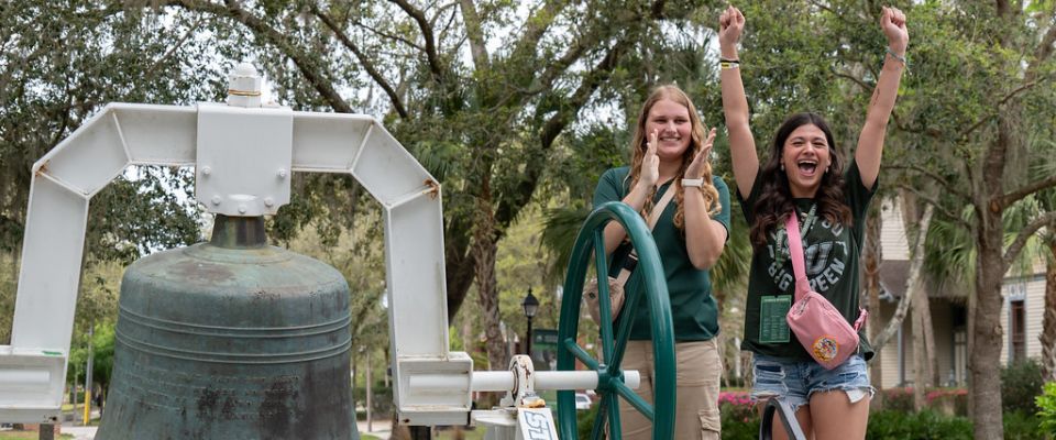 ambassadors ringing green bell with an incoming student