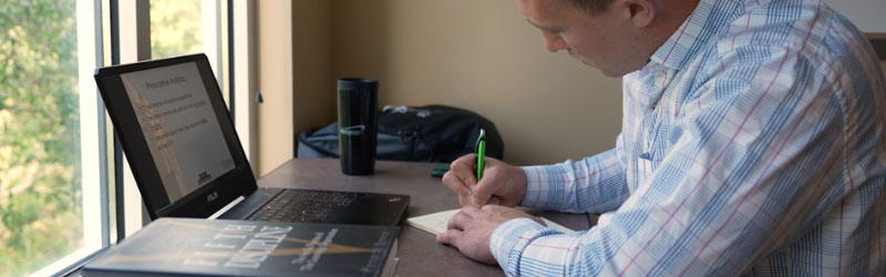 A student taking notes whole attending a class online