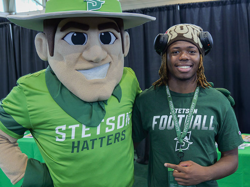 prospective student posing with John B. mascot