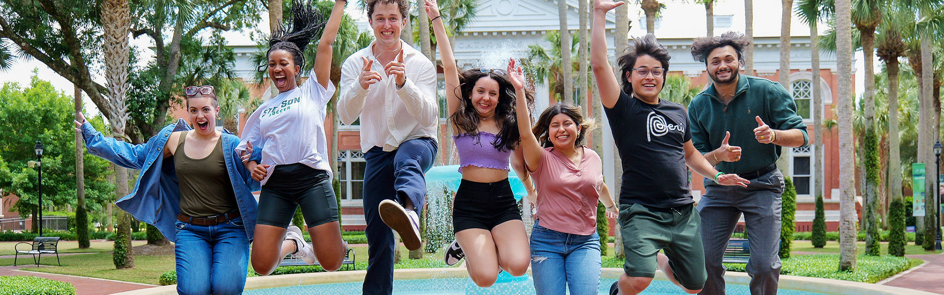 students jumping off fountain