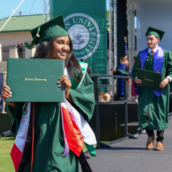 two students walking down the graduation stage