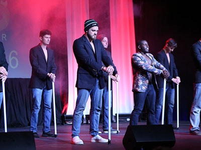 group of guys dressed up dancing on stage