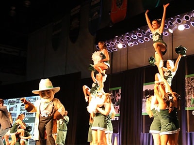 Mascot with cheerleaders on stage dancing