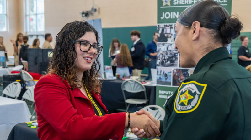 Student shaking hands with employer at career expo