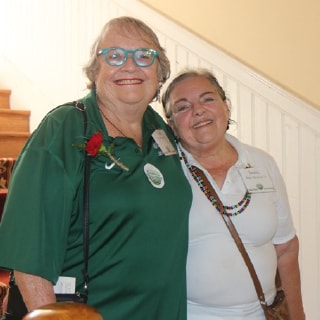Tina Wolf-Wiley and Janice Bartolotta standing by Chaudoin Hall staircase