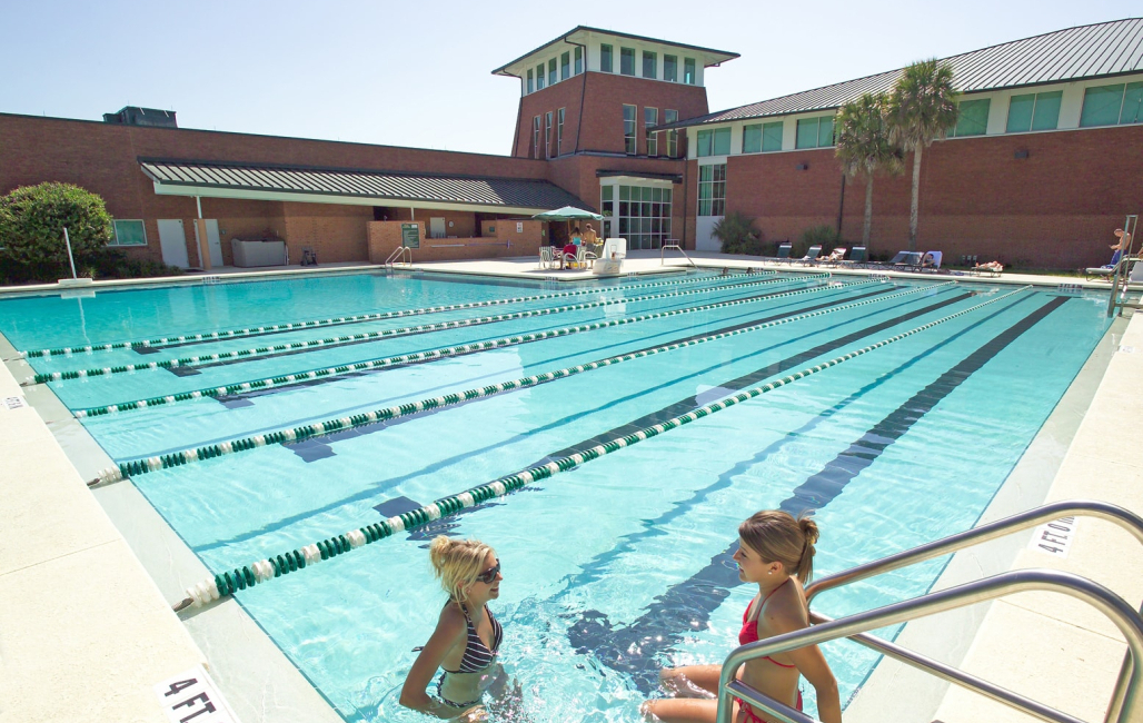 two girls sitting in the edge of the pool