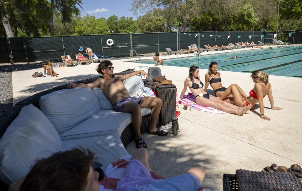 people sitting down outside the pool