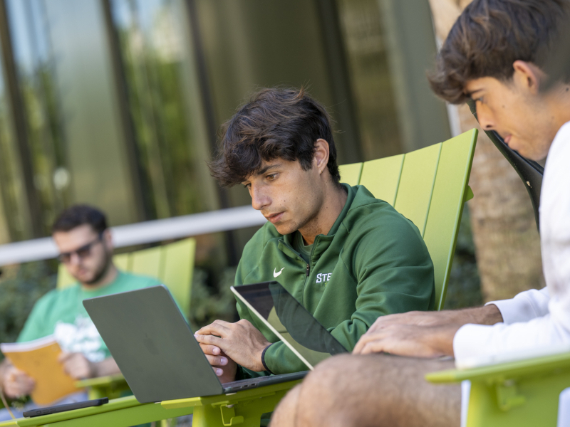 two students sitting down on their computers