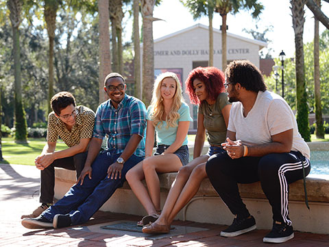 group of smiling students sitting in the fountain
