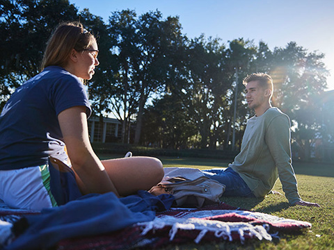 two students sitting in the grass enjoying their day