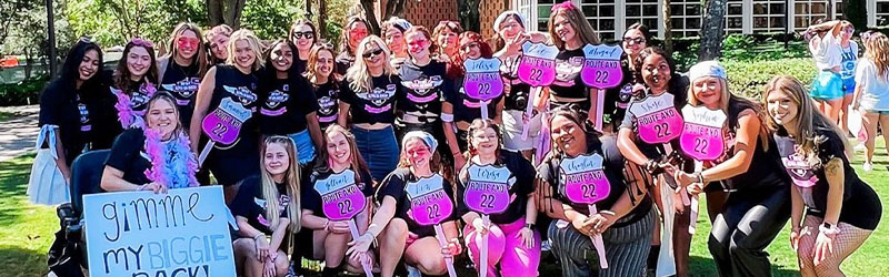 students from sorority posing and smiling together holding individual signs