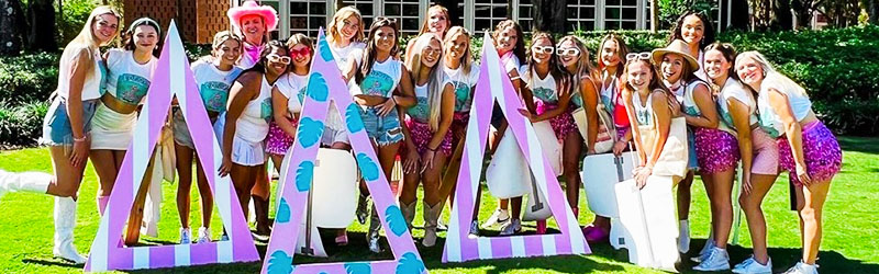 students from sorority posing and smiling together holding their symbol signs