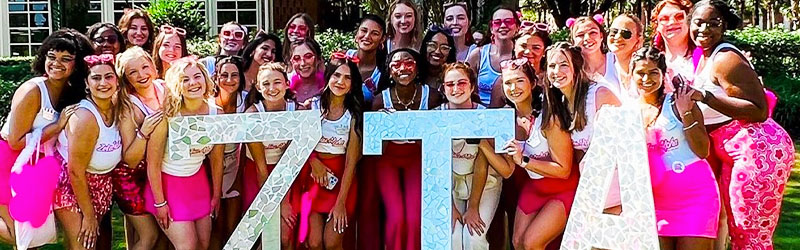 students from sorority posing and smiling together holding their symbol signs