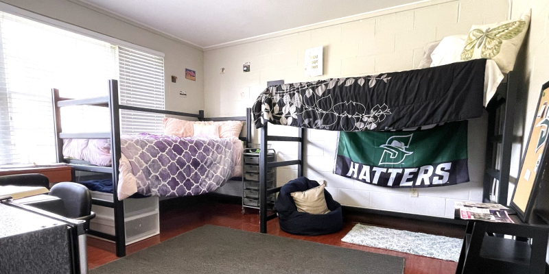 view of a room with two beds and desks 