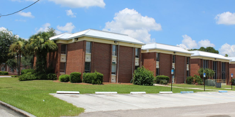 The red brick exterior of Nemec Hall, rear view plus parking lot