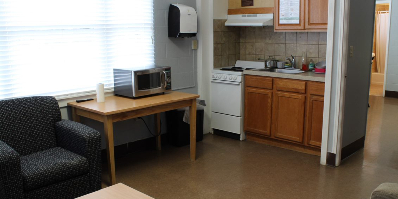 Kitchen of Smith Hall, with stove, oven, microwave, sink, tables and armchair