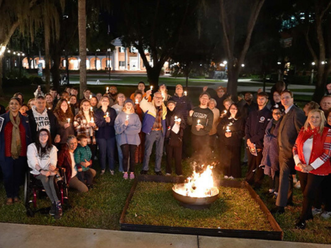 Students gathered holding a candle for the Yule Log Lighting