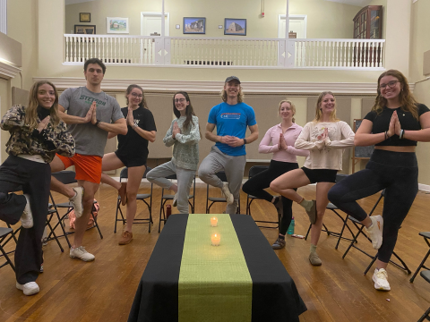 Eight people doing a yoga pose at a PAUSE event