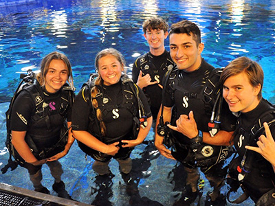 four students from the scuba club with their gear