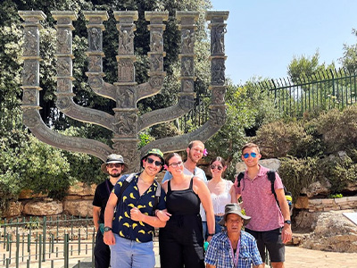 students from Hillel with professor in front of statue