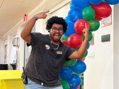 escited student pointing to balloons