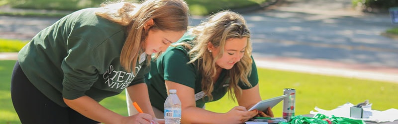 two students with stetson shirts outside