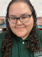 Gabby is wearing glasses and a green Stetson polo.