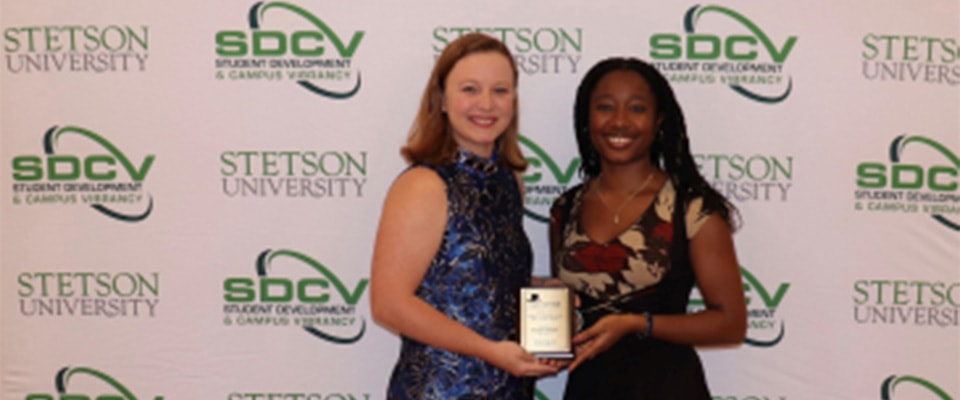 student and fronk scholars director reciving top hatter award