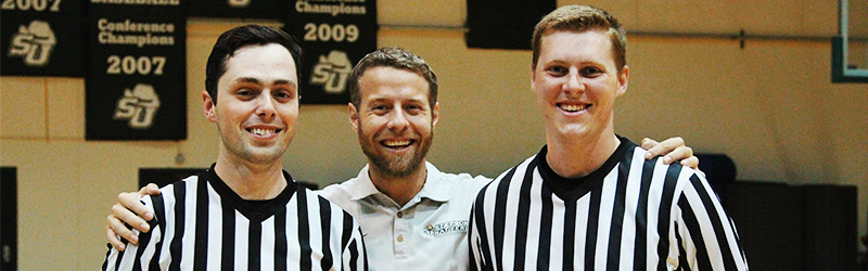 two students referees next to Travis Potter