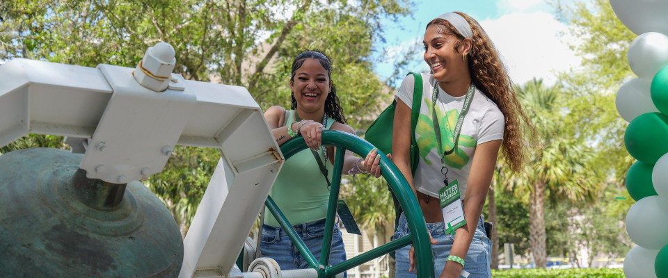 two students ringing bell during hatter saturday