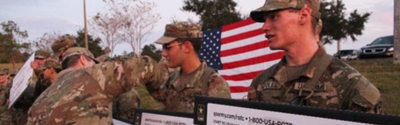 students from rotc in uniform reciving giant checks