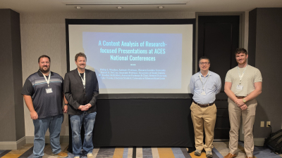 McKibben, DeCino, Waalkes, and Tooley standing in front of their presentation
