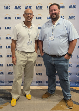 professors eng and mckibben smiling in front of an aarc backdrop