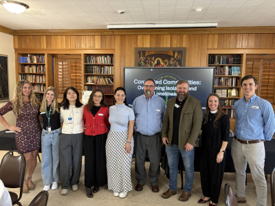 nine people in a row smiling at the camera