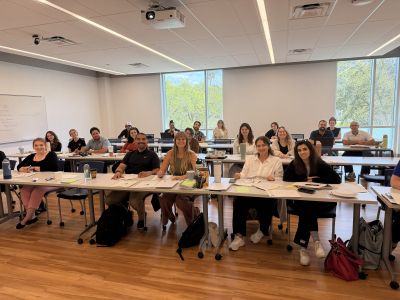 a large classroom full of many people smiling at camera