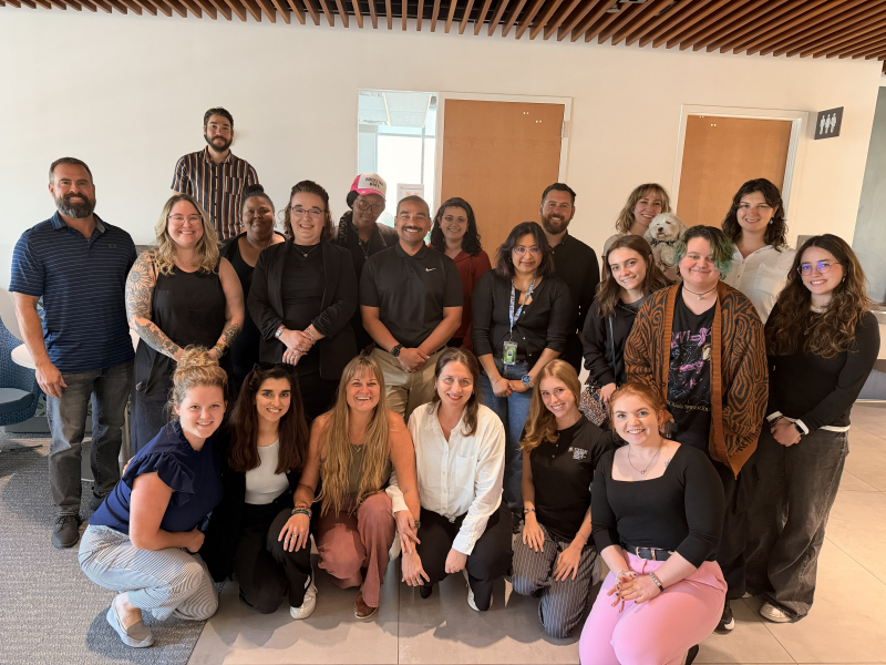 a group of students, faculty, and alumni posing for a group photo