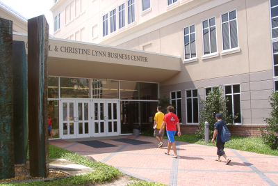 three students walking in the main entrance to the business center