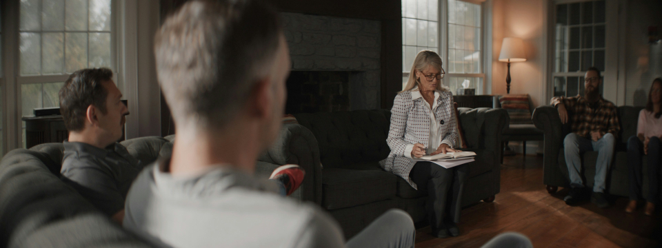 woman sitting in the middle of a group for therapy