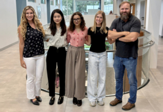 five people smiling in a group photo