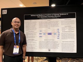 timothy eng smiling next to a conference poster