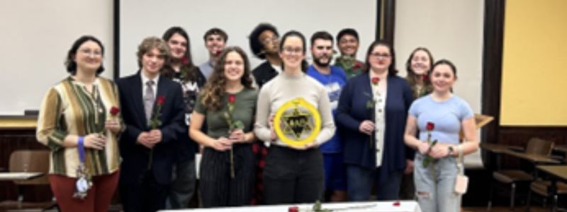 Phi Alpha Theta group holding emblem