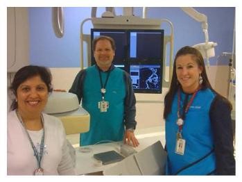 Three healthcare professionals posing for a picture in a radiology room