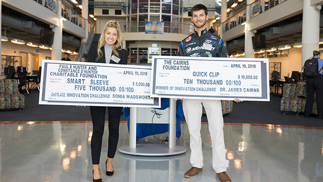 Students holding their checks from the Cairns Innovation Challenge 2018