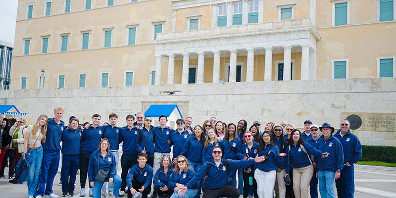 group picture of students in frong of landscape of ruins in greece