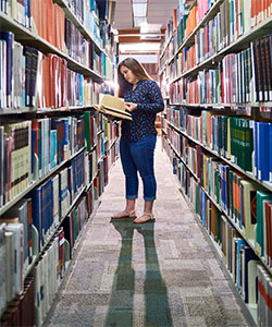 A girl reading a book in the library